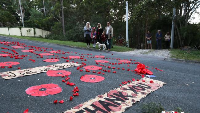 Alex Sit, Carmelina Kannelmae, Gabrielle Sit and their children Theodore and Liila Moelder-Sit honour the Anzacs during a dawn driveway service at Elanora on the Gold Coast. Photograp: Jason O'Brien