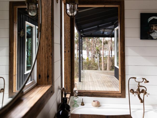 The Voyager’s downstairs bathroom with its deep freestanding bath, aged brass tapware and peaceful views out over the deck to the river is the perfect place for a relaxing soak in the tub. Picture: Supplied.