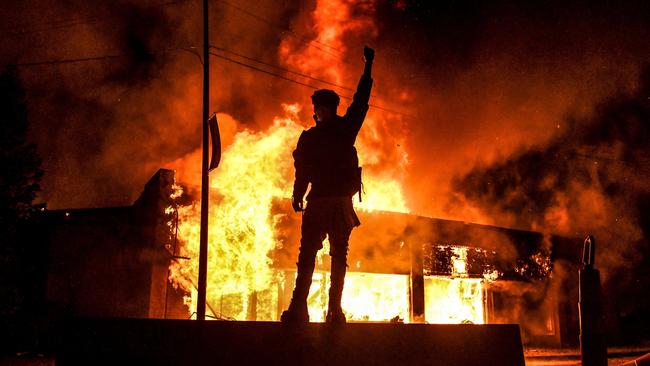 A protester reacts standing in front of a burning building set on fire during a demonstration in Minneapolis, Minnesota, on May 29, 2020, over the death of George Floyd. Picture: AFP