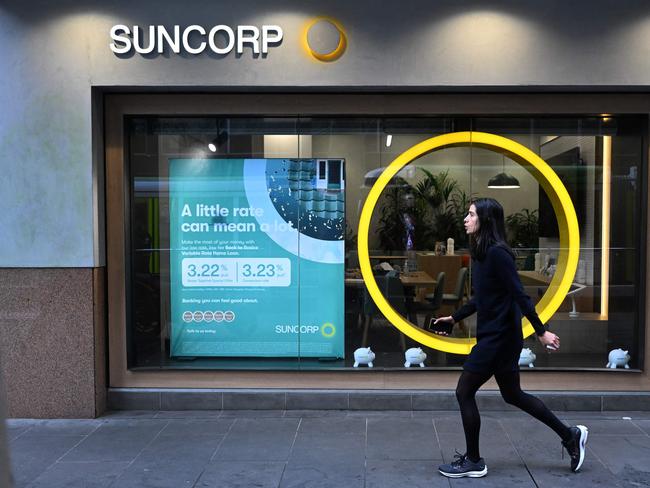 A pedestrian walks past a Suncorp Bank branch in Melbourne on July 18, 2022. - Australian banking giant ANZ announced on July 18 a 3.3 billion USD deal to swallow regional lender Suncorp Bank -- one of the biggest takeovers in the sector for more than a decade. (Photo by William WEST / AFP)