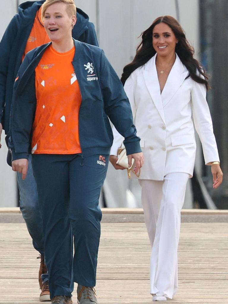 Meghan turned heads in a white double-breasted suit with white shoulder bag and stilettos. Picture: Getty Images