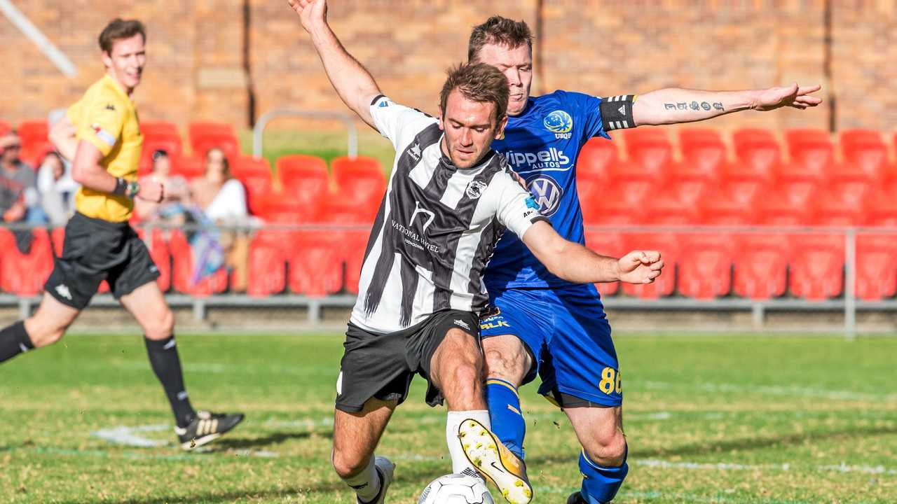 TIGHT TUSSLE: Willowburn's Daniel Saunders (left) shields the ball from USQ FC's Brendan Willmot during their President's Cup Clash. Willowburn won the game 8-7 on penalties after the game finished 2-2. Picture: paulsmith:photographer