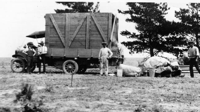 The first load of equipment, including tents and buckets, is unloaded at Point Cook in 1913.