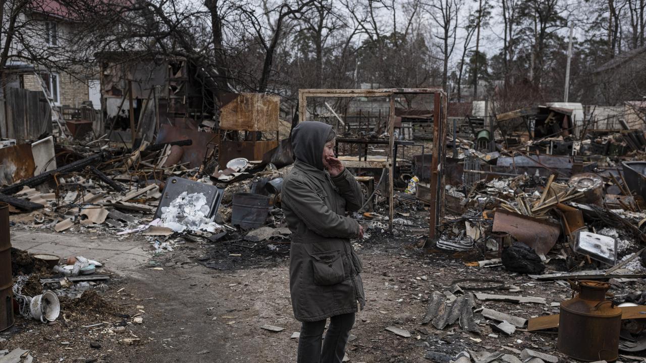 A Ukrainian woman stands next to destroyed constructions in her courtyard in Bucha. Picture: Getty Images