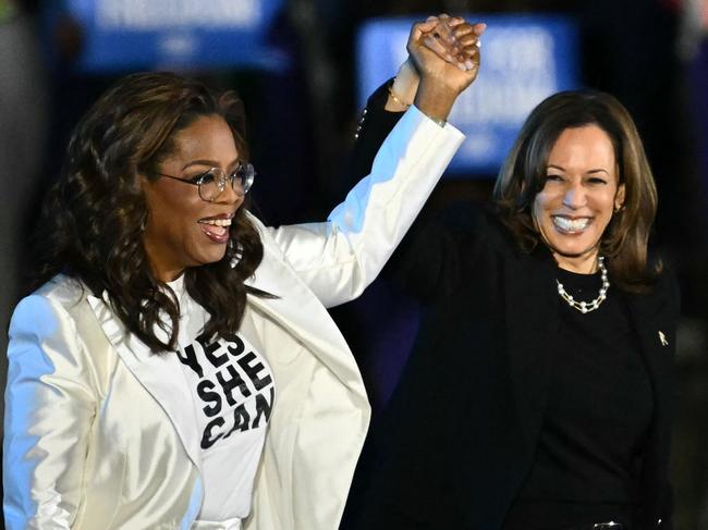 Oprah Winfrey holds up US Vice President and Democratic presidential candidate Kamala Harris' hand as she arrives at a campaign rally on the Benjamin Franklin Parkway in Philadelphia, Pennsylvania, on November 4. Picture: Angela Weiss/AFP