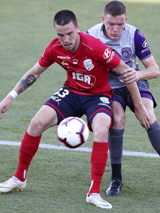 Adelaide’s Apostolos Stamatelopoulos battles Perth Glory’s Shane Lowry. Picture: Sarah Reed