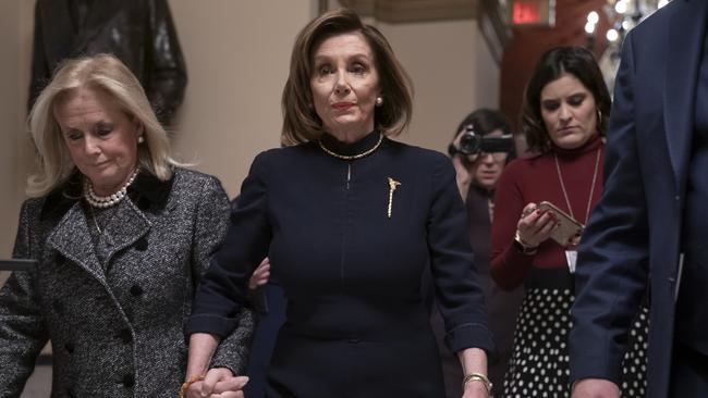 Nancy Pelosi holds hands with fellow Democrat Debbie Dingell as they walk to the chamber for the impeachment debate. Picture: AP.