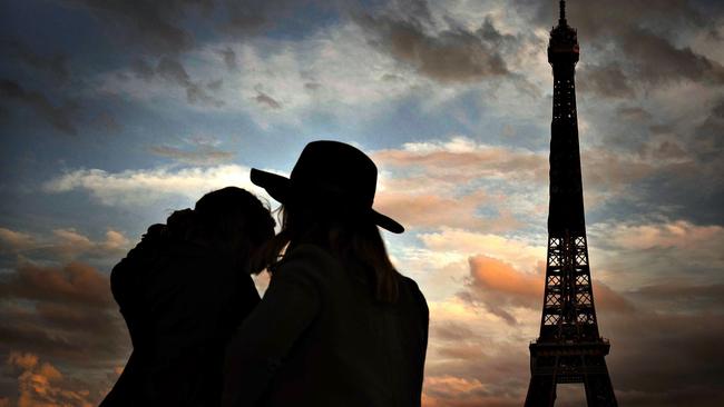 Two persons face the Eiffel Tower in Paris. Picture: AFP