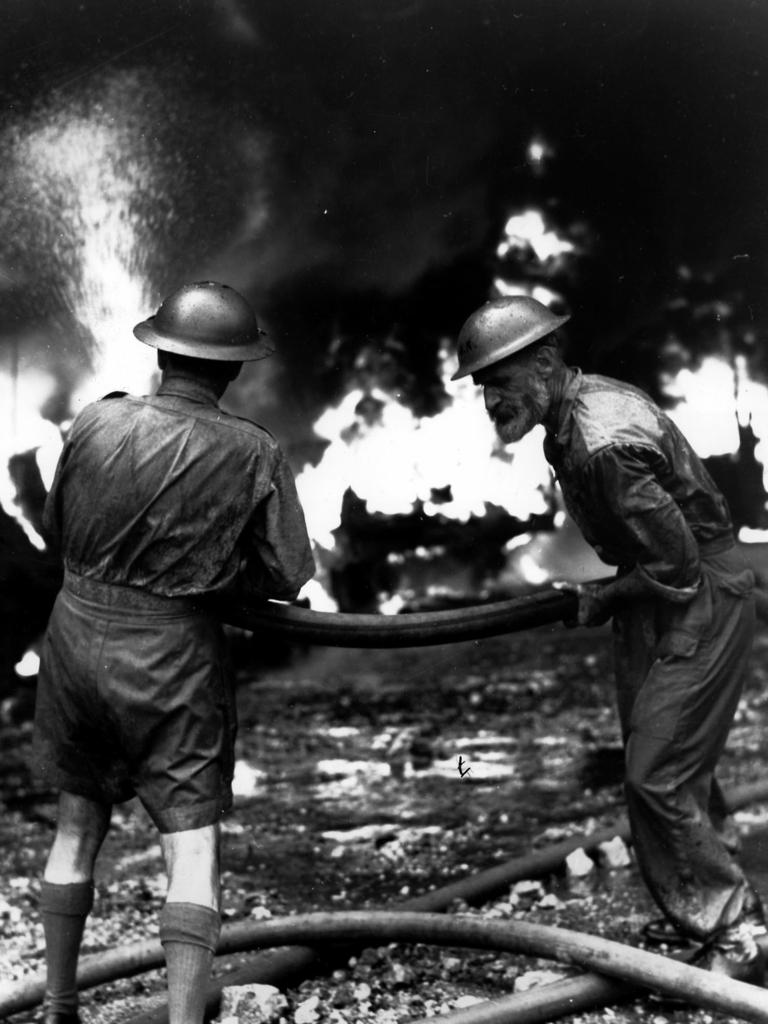 Under relentless air raids by the Japanese, volunteers fight fires at the docks in Singapore in 1942.