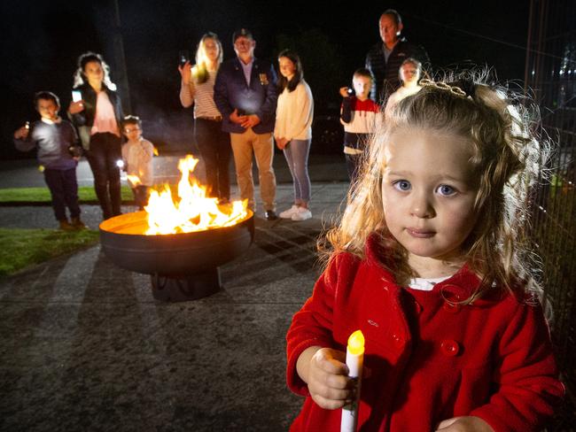 Chris McAleer is setting up a fire pit as his version of the eternal flame at the end of his driveway as a tribute to Anzac Day for the whole street to gather around for the Dawn Service. Natalia 2, holds an old ANZAC Day candle and also the future of ANZAC Day spirit with her mum (left) Carmen Galea-Pace and brothers Julian 8, Oliver 5, neighbours Chris McAleer (center) with his wife Megan and daughter Alannah 12, (right) Mark Gilham with children Oliver 8 and Jaime 10, having a trial run of the Dawn Service in the driveway.         Picture: David Caird