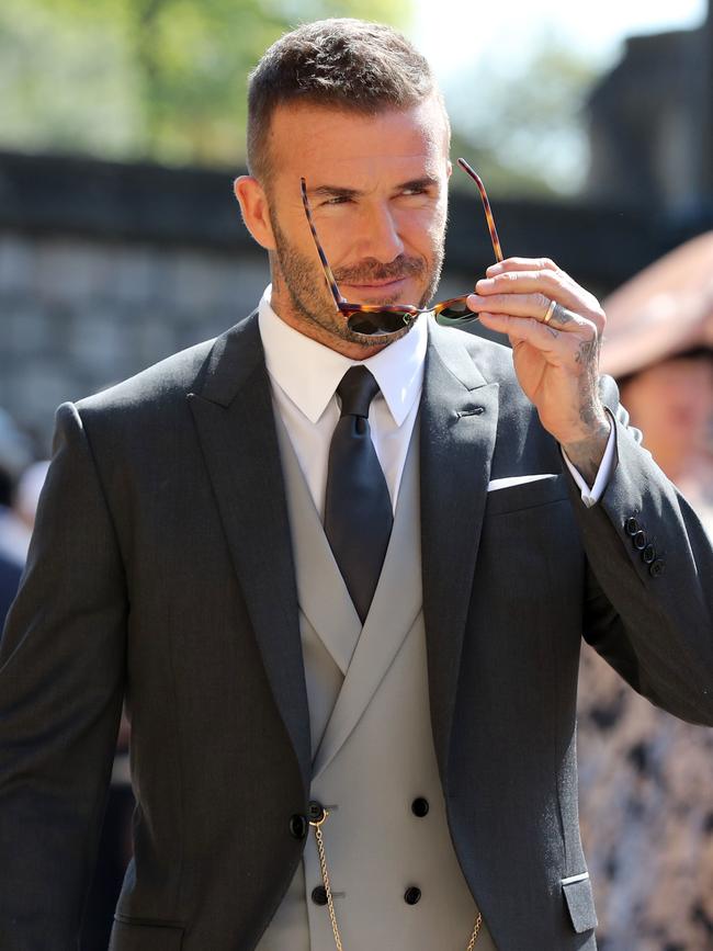 Becks teamed his grey suit with a pair of shades. Picture: AFP