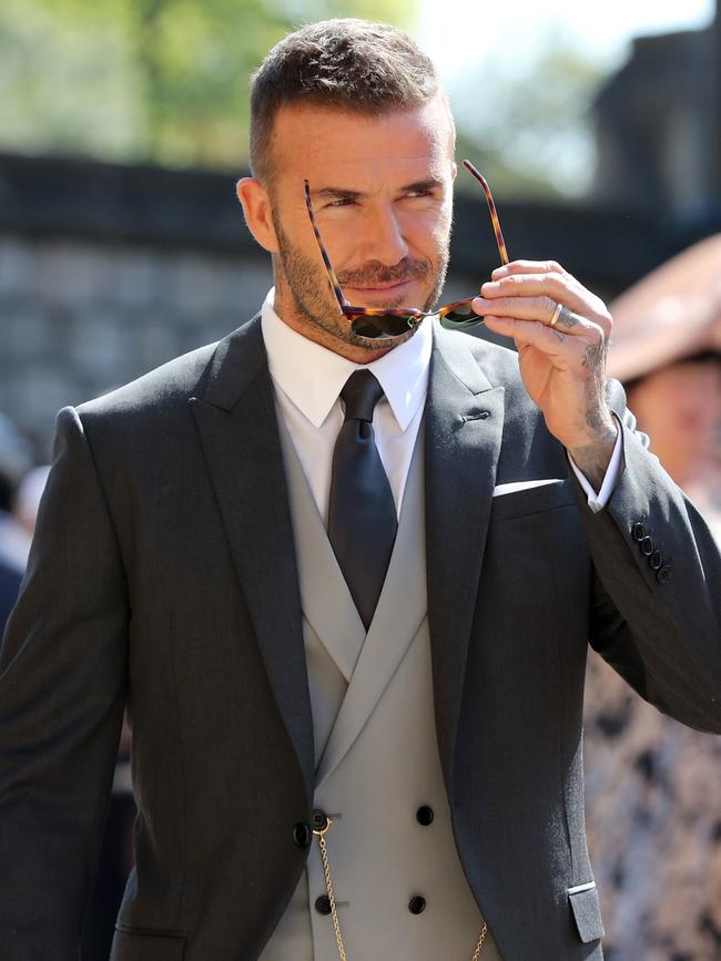 Becks teamed his grey suit with a pair of shades. Picture: AFP