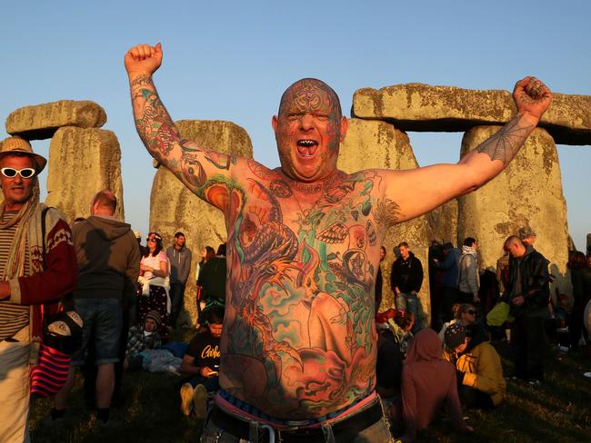 Rock festival ...  a reveller called Mad Alan celebrates the 2014 summer solstice, the longest day of the year, at sunrise at the prehistoric monument Stonehenge, near Amesbury in Southern England.