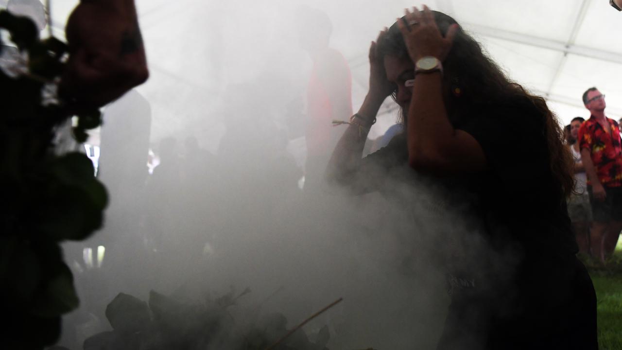 People walk through the smoking ceremony at Darwin Waterfront celebrations. Picture: (A)manda Parkinson