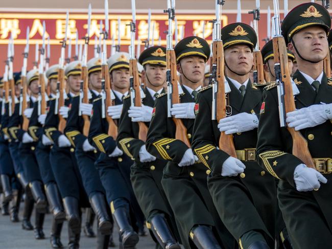 BEIJING, CHINA - JANUARY 01: The Guard of Honor of the Chinese People's Liberation Army (PLA) escorts the national flag during a flag-raising ceremony at the Tian'anmen Square to celebrate New Year's Day on January 1, 2023 in Beijing, China. (Photo by VCG/VCG via Getty Images)