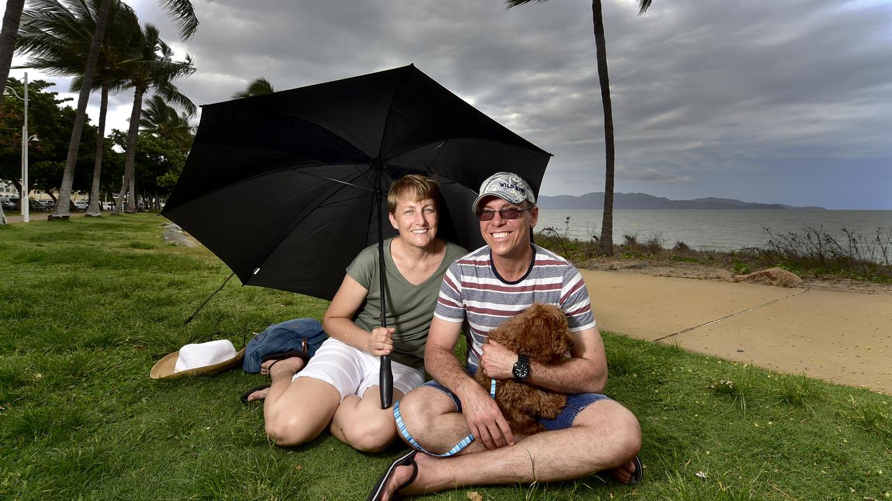 Dark clouds gather as Jodie and Jason Shepherd take pup Charlie on his first walk on the Strand. (FILE PHOTO) Picture: Matt Taylor.