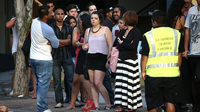 Partygoers wait for a taxi after leaving nightclubs in the broad daylight. Pic by David Clark