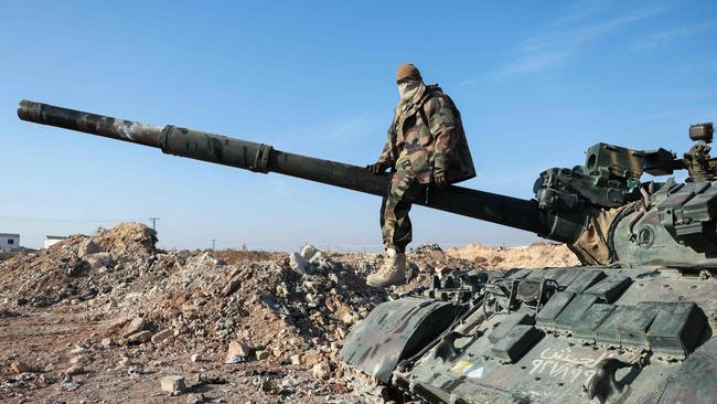 A militant poses for a picture after anti-government fighters seized Syrian army military equipment that were abandoned on the highway to Damascus. Picture: Omar Haj Kadour/AFP