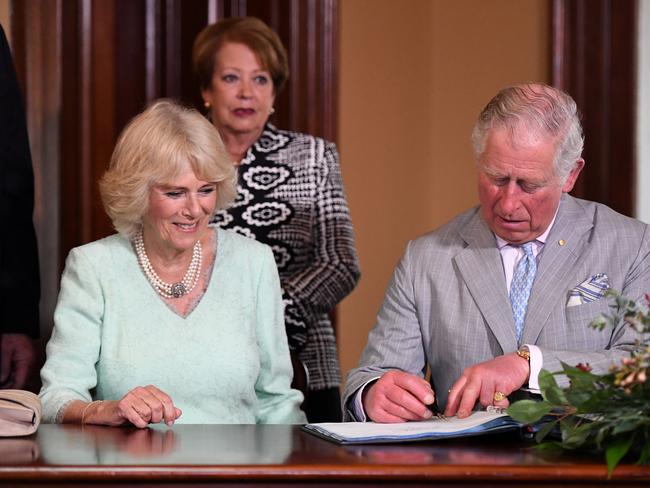 Prince Charles and his wife Camilla sign the guest book at Old Government House in Brisbane. Picture: Dan Peled/AAP