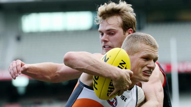 Jack Watts, playing for Melbourne, tackles Adam Treloar, for GWS, in 2014.