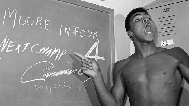 Muhammad Ali points to a sign he wrote on a chalk board in his dressing room before his fight against Archie Moore
