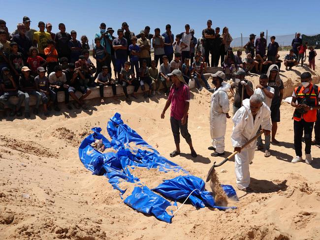 Men burry bodies that were taken and later released by Israel during a mass funeral at a cemetery in Khan Yunis in the southern Gaza Strip. Picture: AFP