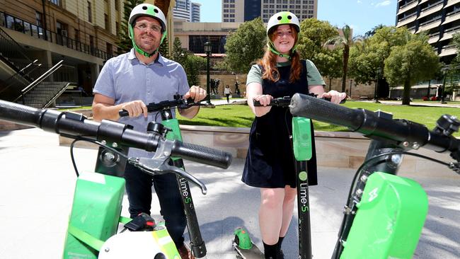 Chris Isles and Caitlin Wood try out Lime e-scooters. Users can now unlock multiple scooters with one account. Picture AAP/David Clark