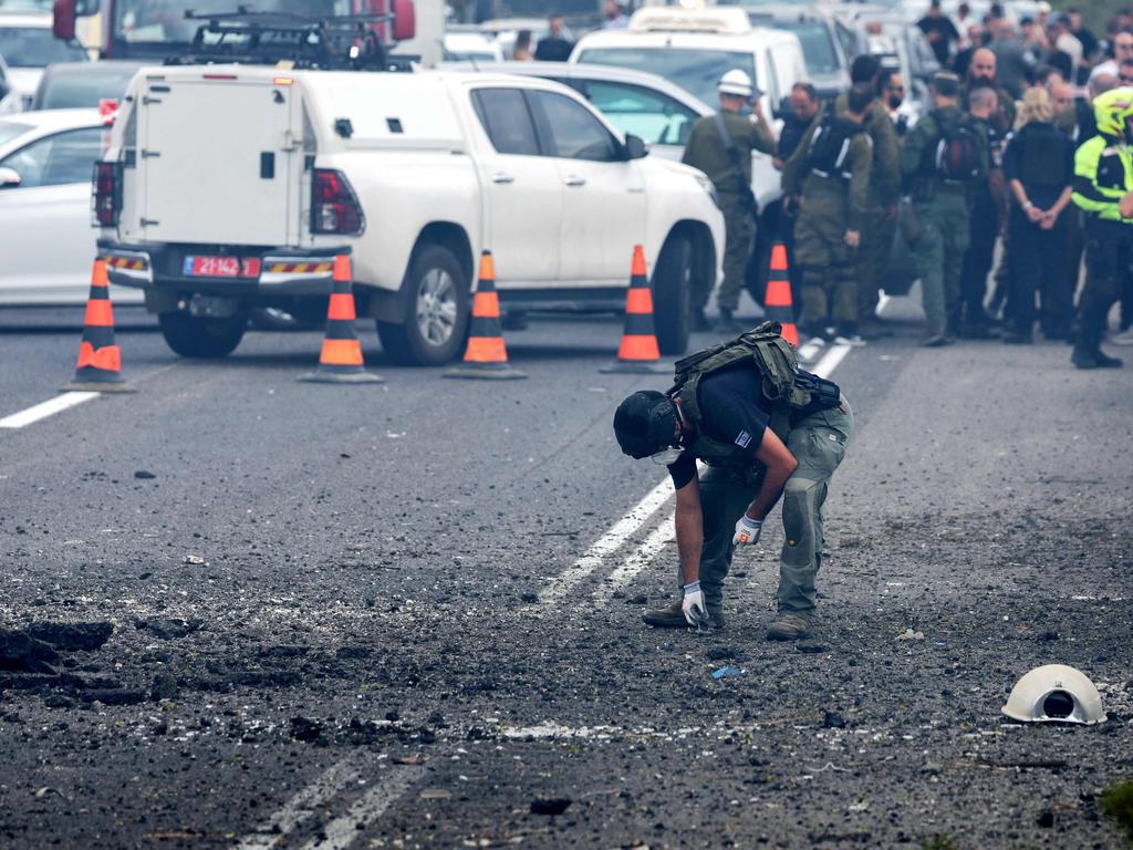 Israeli emergency and security personnel deploy at the impact site of a reported rocket fired from Lebanon, on the Horeshim interchange in central Israel on October 1, 2024.