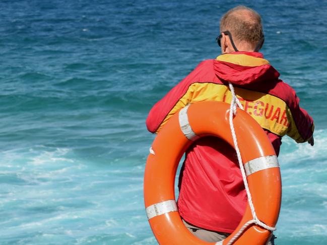 Surf Life Savers search for a drowning victim from the rocks at the Fingal Head Lighthouse, Fingal Head.