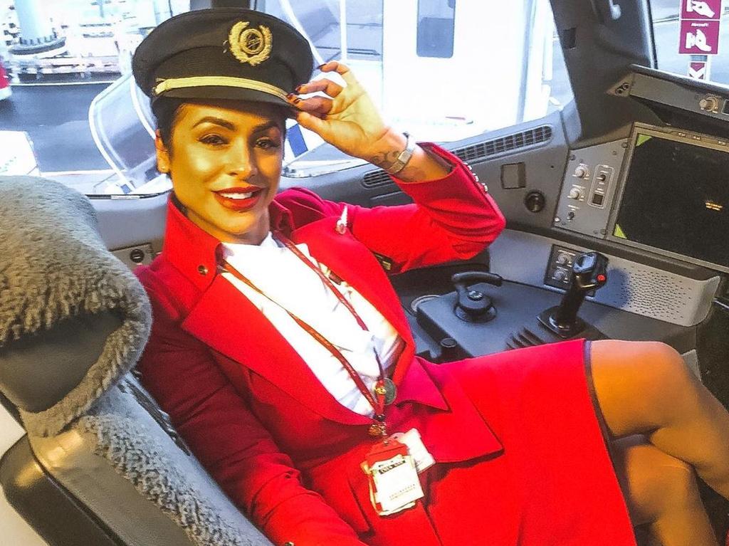 Sara poses in the cockpit in her work as an air stewardess.