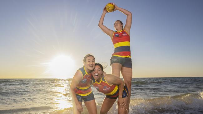 Crows Ebony Marinoff, Hannah Munyard and Caitlin Gould warm up for the season at Tennyson Beach. Picture: Simon Cross