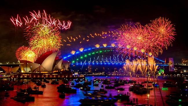 TOPSHOT - Fireworks explode over the Sydney Harbour Bridge and Sydney Opera House (L) during New Year's Eve celebrations in Sydney on January 1, 2024. (Photo by Izhar KHAN / AFP)