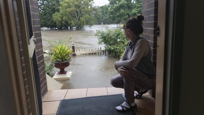 Windsor resident Kelly Miller can only watch as flood waters reach her workplace, a 100-year-old property near the Windsor CBD. Picture: Brook Mitchell/Getty Images