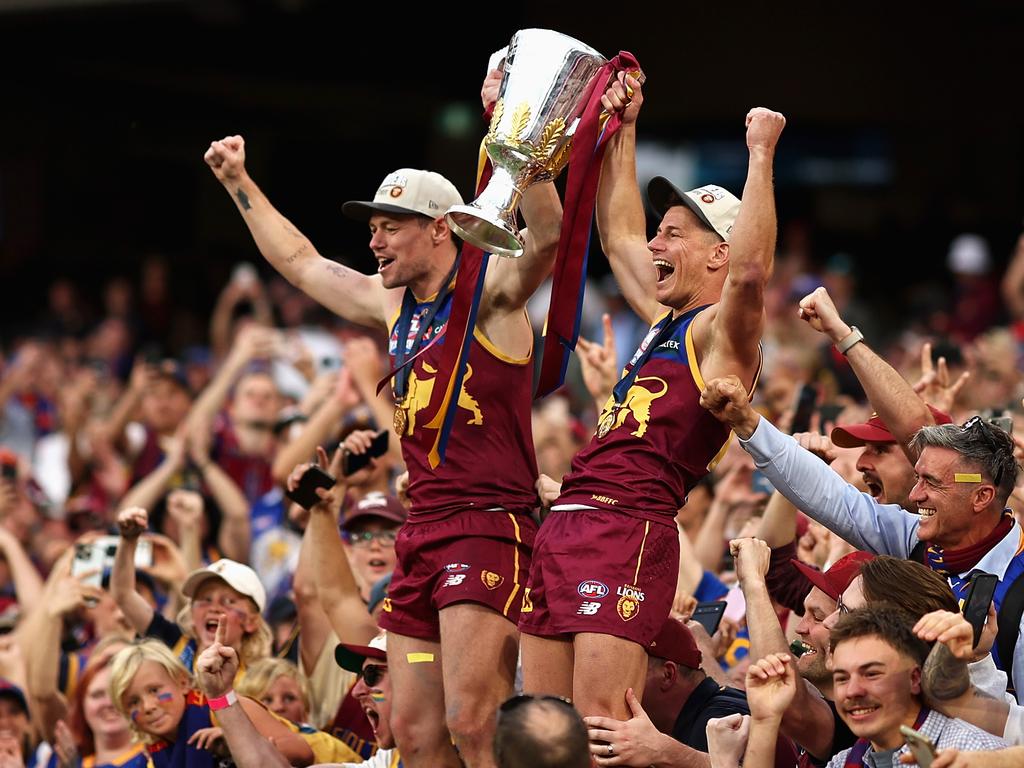 Lachie Neale and Dayne Zorko of the Brisbane Lions celebrate with fans and the AFL Premiership Cup after their victory in the AFL Grand Final against the Sydney Swans at the Melbourne Cricket Ground. Picture: Getty