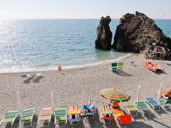 Monterosso, Cinque Terra, Italy. beach with colorful rainbow chaise lounge chairs and umbrellas. resort beach. old fishing village and tourist destinationPhoto - iStockESCAPE 27 March 2022My  Hols
