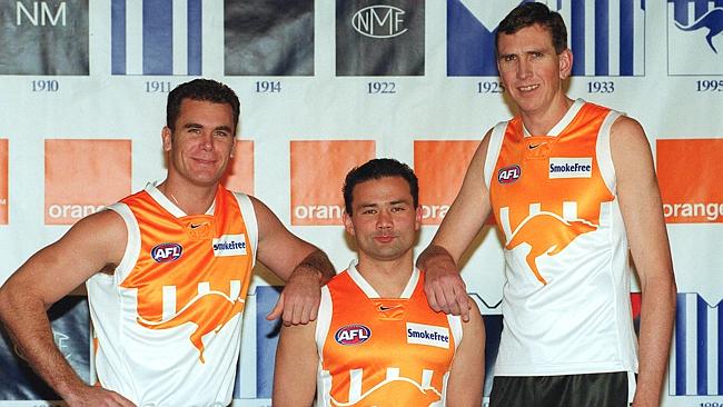 Wayne Carey (l) with Peter Bell and Matthew Burton wearing the Kangaroos’ sponsored orange guernsey from 2000.