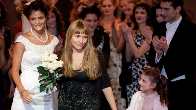 Collette Dinnigan (C) receives applause from models at the end of her Autumn/Winter 1998-99 ready-to-wear fashion collection.