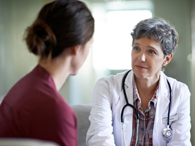 Shot of a compassionate doctor comforting a young woman in a hospital waiting room; fear health scare generic