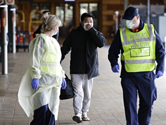 A man is taken away for further COVID-19 testing after travelling on the XPT from Melbourne at Central. Picture: Adam Yip