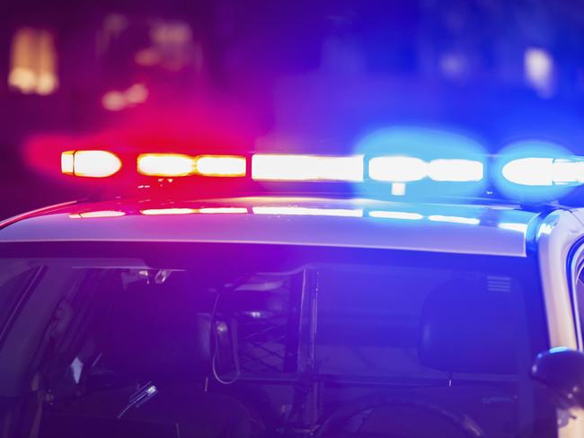 The roof of a police patrol car at night, with the blue and red lights flashing.