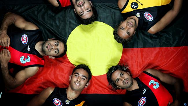 Essendon's Nathan Lovett-Murray, Dean Rioli and Andrew Lovett and Richmond's Richard Tambling and Andrew Krakouer with the Aboriginal flag to promote the Dreamtime at the 'G match in 2005. Picture: Michael Klein