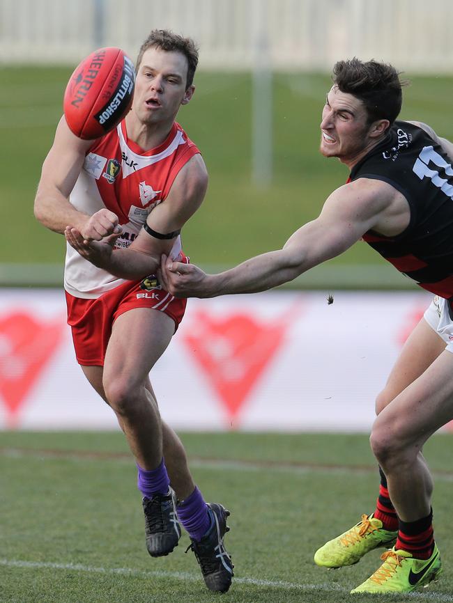 Clarence's Trent Standen gets his handball away from Lauderdale's Ryan Wiggins Picture: LUKE BOWDEN