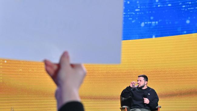 Ukrainian President Volodymyr Zelensky drinks water during his end-of-year press conference in Kyiv.