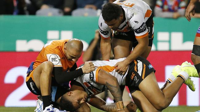 Michael Chee Kam receives attention after suffering a head knock in a collision with Kalyn Ponga. Picture: AAP Image/Darren Pateman