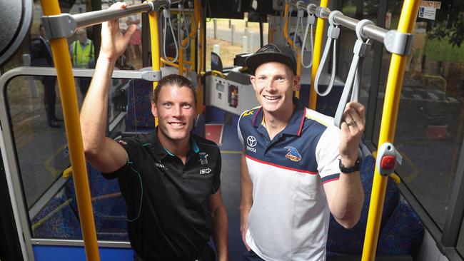 Brad Ebert of Port and Sam Jacobs of the Crows on a Footy Express bus.