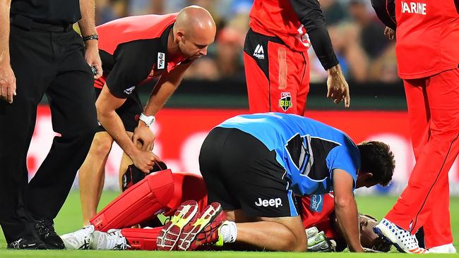 Peter Nevill lays on the ground after being struck in the head.