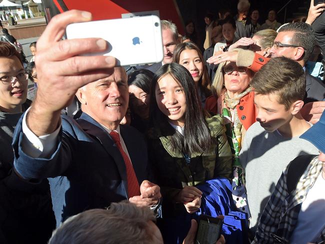 Australian Prime Minister Malcolm Turnbull takes selfies with locals during a street walk ahead of arriving at the Sunny Harbour Yum Cha in the federal seat of Barton in the Sydney suburb of Hurstville, Wednesday, June 29, 2016. A federal election will be held in Australia on Saturday July 2. (AAP Image/Lukas Coch)