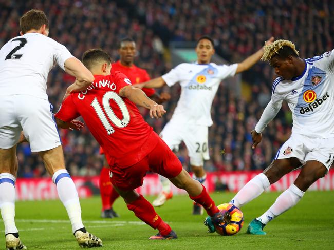 Dider Ndong of Sunderland and Philippe Coutinho of Liverpool compete for the ball.