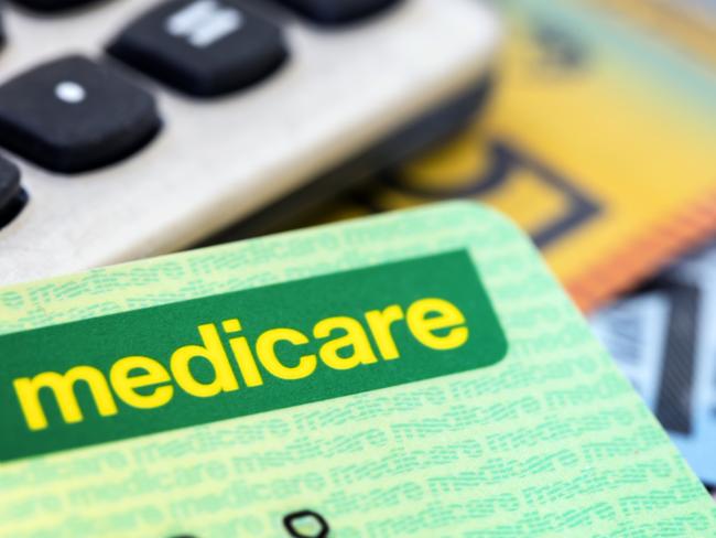 Australian Medicare card with calculator and cash background.