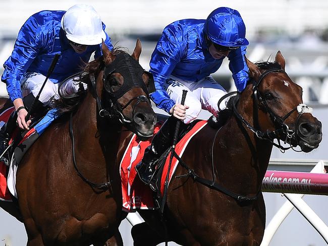 Jockey Pat Cosgrave (right) drives Benbatl to victory ahead of James Doyle and Blair House in the Caulfield Stakes. Picture: AAP